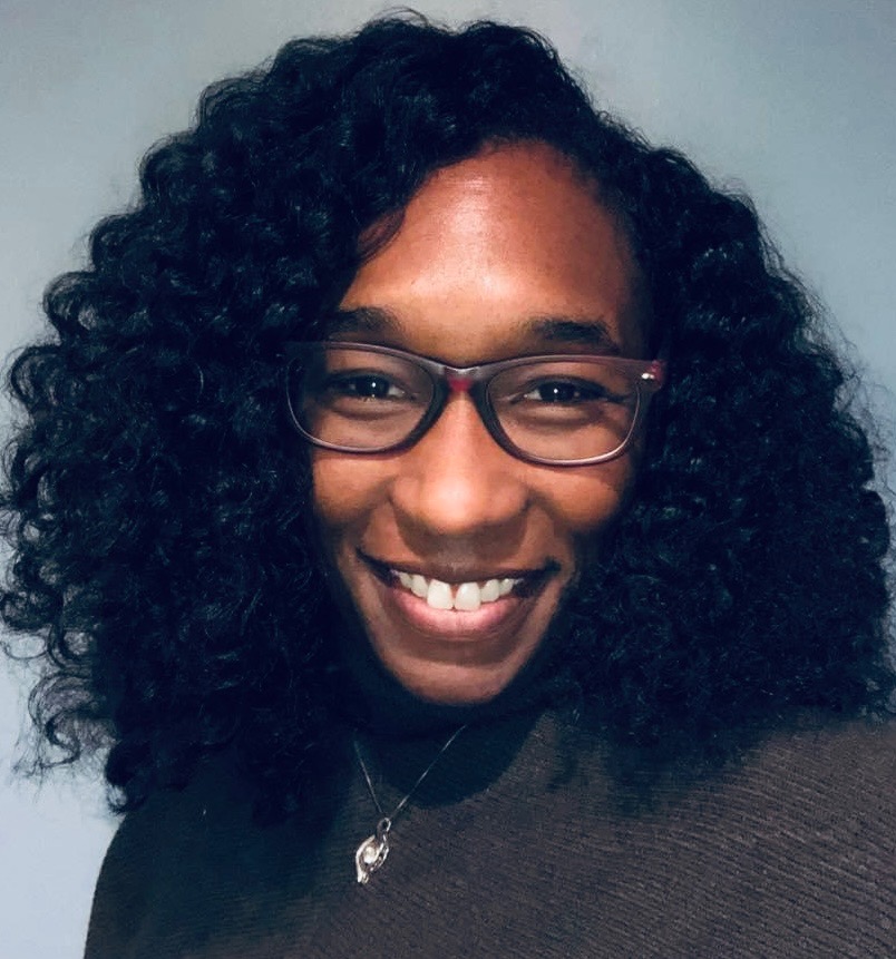 Photo of women with black curly hear and glasses
